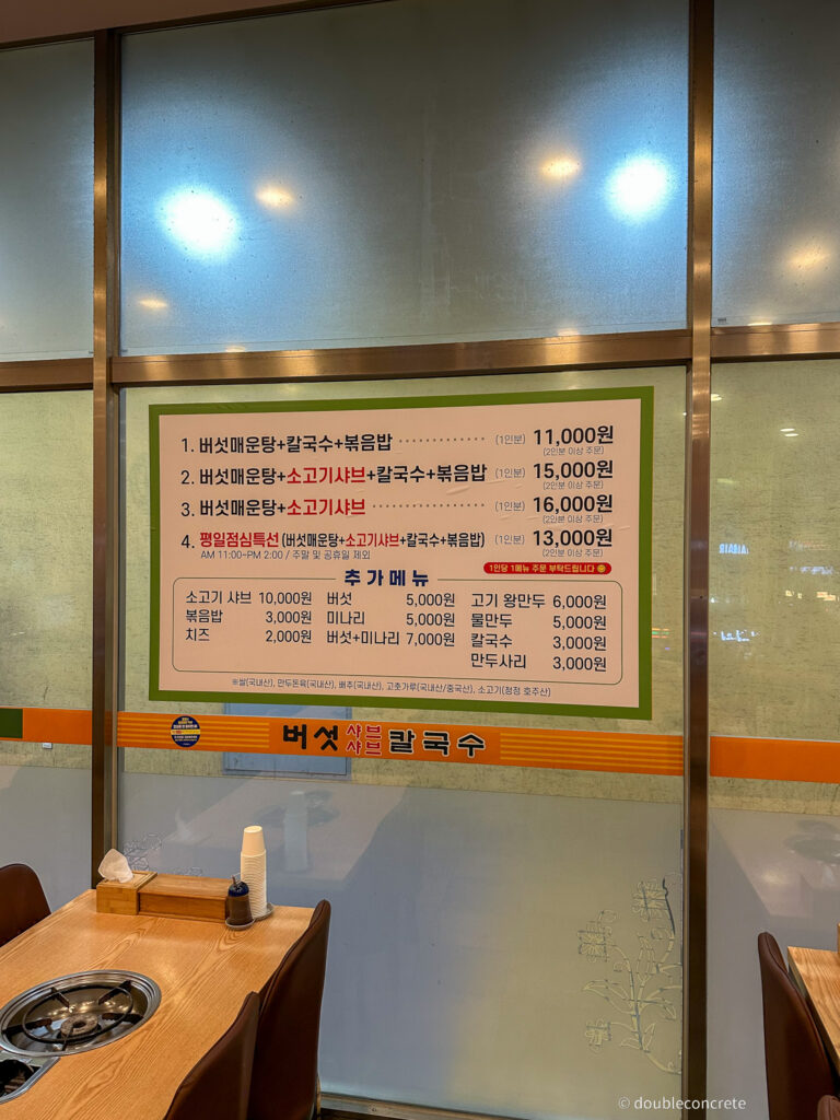 가게 내부 벽에 부착된 메뉴판, 버섯매운탕과 샤브샤브 가격이 적혀 있다.