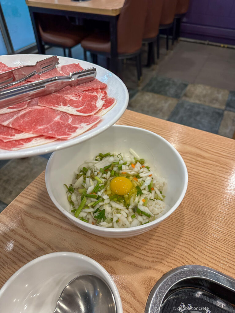 밥 위에 계란과 채소가 올라가 있는 모습, 볶음밥을 만들 준비가 되어 있다.