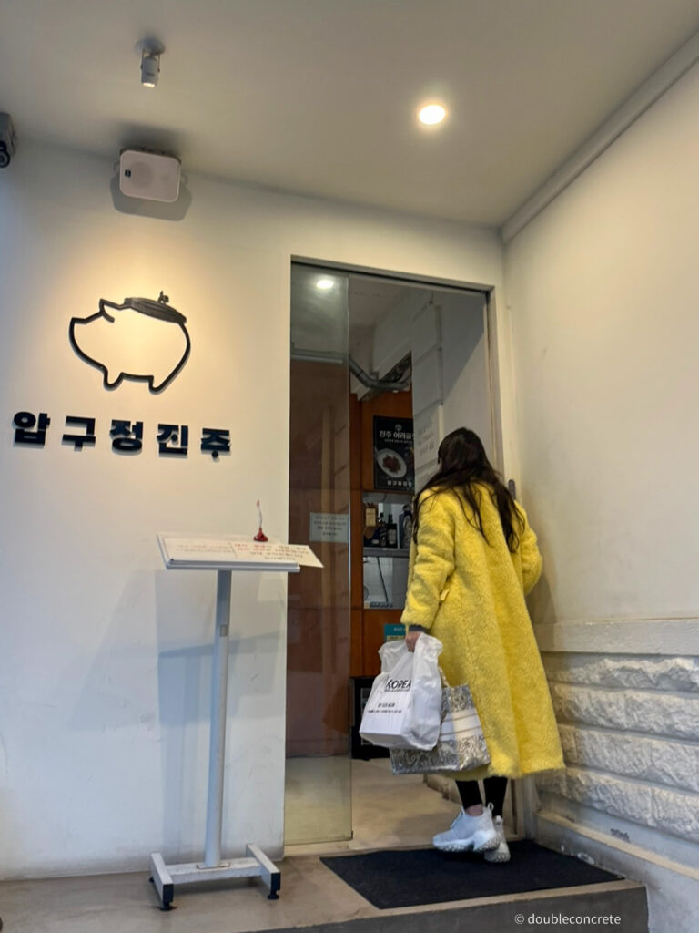 압구정진주 입구에서 노란색 외투를 입은 친구가 가게로 들어가는 모습