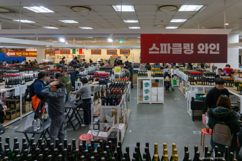 와인 행사장 입구로 내려가는 에스컬레이터와 스파클링 와인 안내판