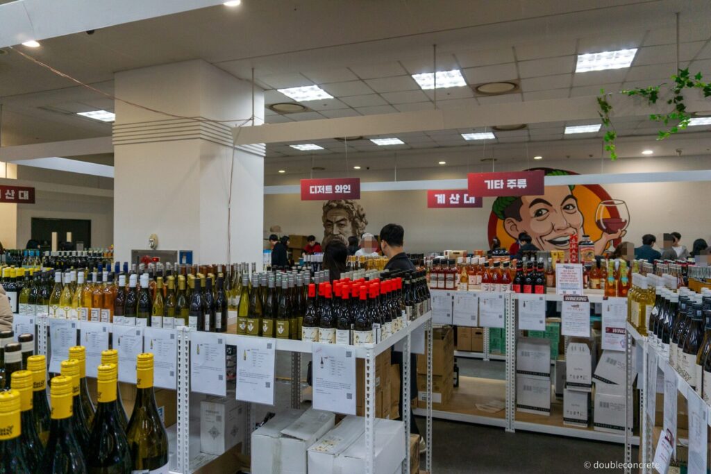 인기 와인들이 진열된 코너, 품절된 제품과 쇼핑하는 사람들