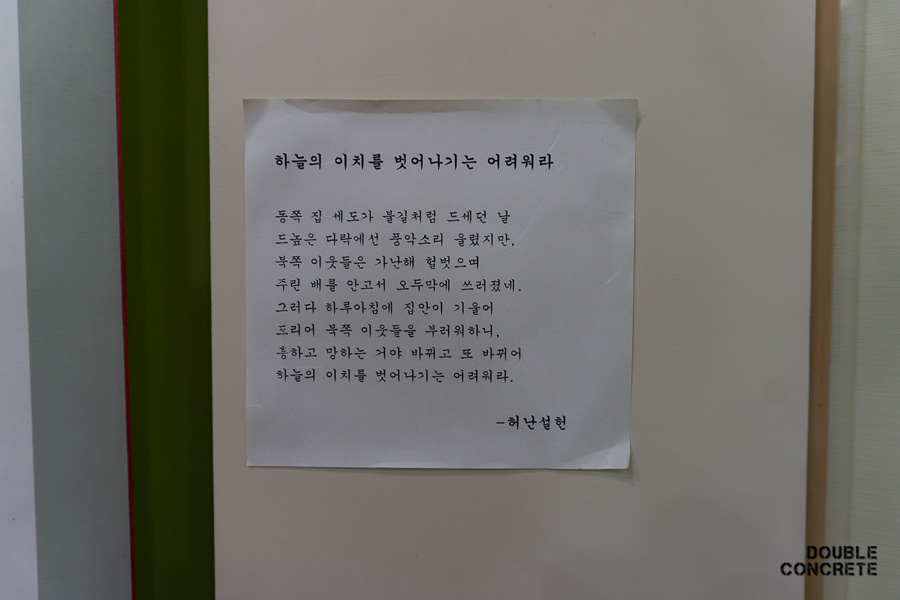 허난설헌의 시 '하늘의 이치를 벗어나기는 어려워라'가 인쇄되어 벽면에 부착된 모습