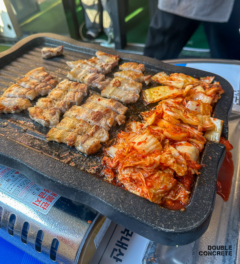 잘 구워진 삼겹살과 노릇하게 익은 김치가 나란히 놓인 불판