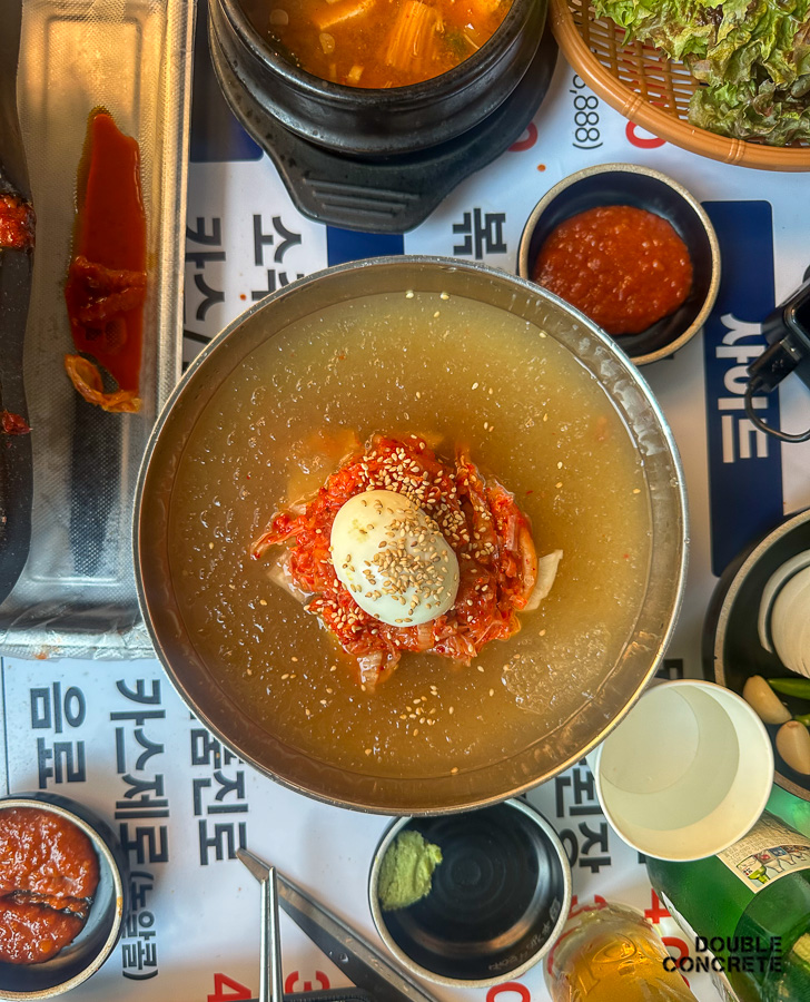 계란과 김치가 올라간 김치말이 스타일의 신돈냉면