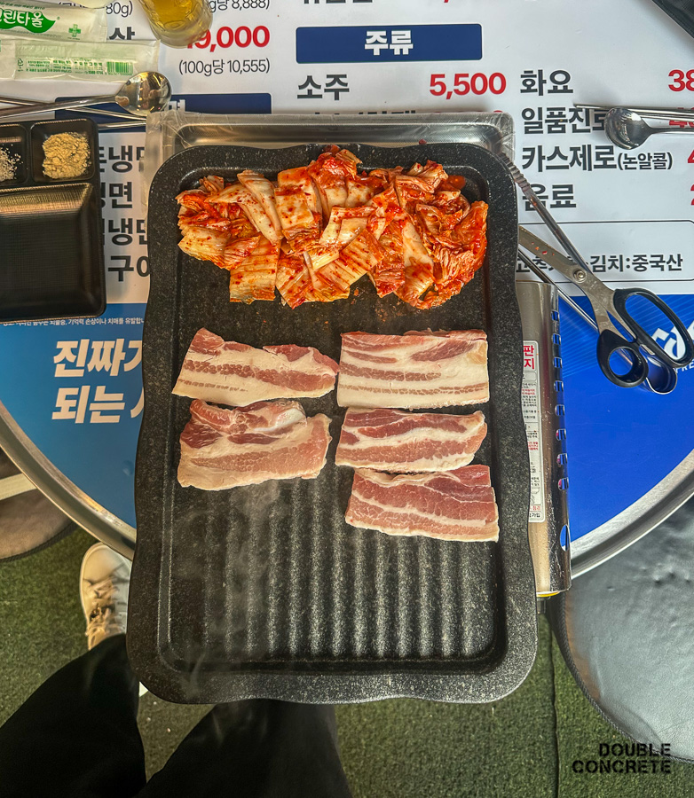 불판 위에 구워지는 생삼겹살과 김치