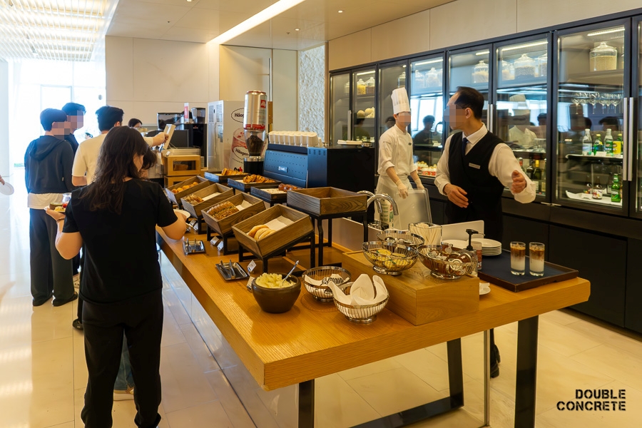 Guests are selecting from an array of freshly baked bread and pastries at the bakery section of The Restaurant.