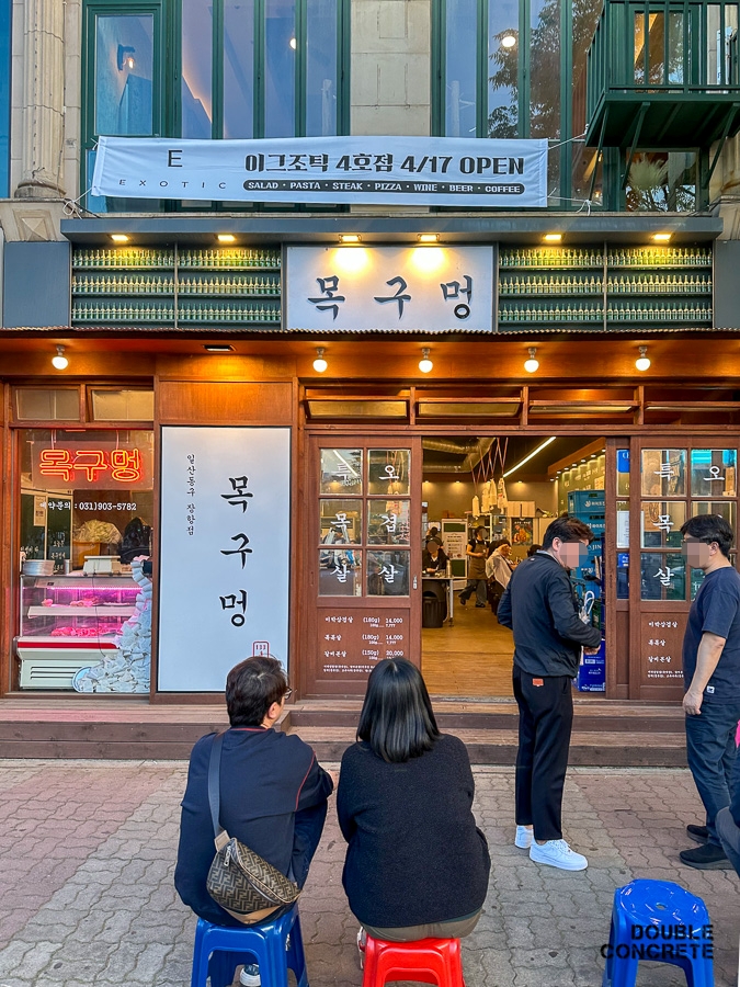 목구멍 고양장항점의 외관. 손님들이 대기 중인 모습이 보이며, 식당 간판과 함께 이곳의 분위기를 담은 사진.