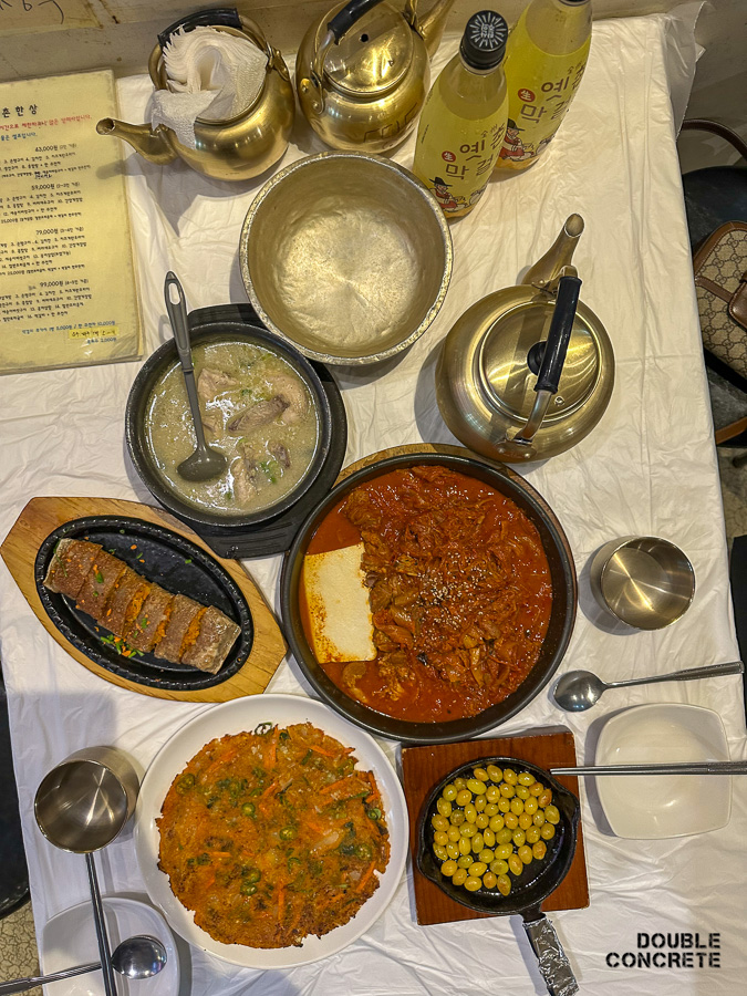 옛촌 커플상 전체 구성, 다양한 안주가 놓여 있음