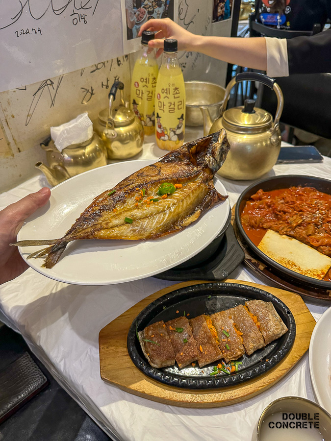 생선구이와 메밀전병이 테이블에 놓여 있는 모습