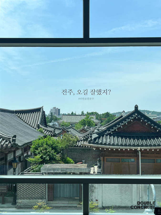 유리창 너머로 보이는 전주 한옥지붕과 '전주, 오길 잘했지?' 문구