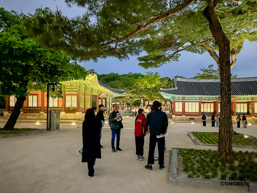 조명이 밝혀진 통명전 앞에서 교수님이 설명 중인 모습