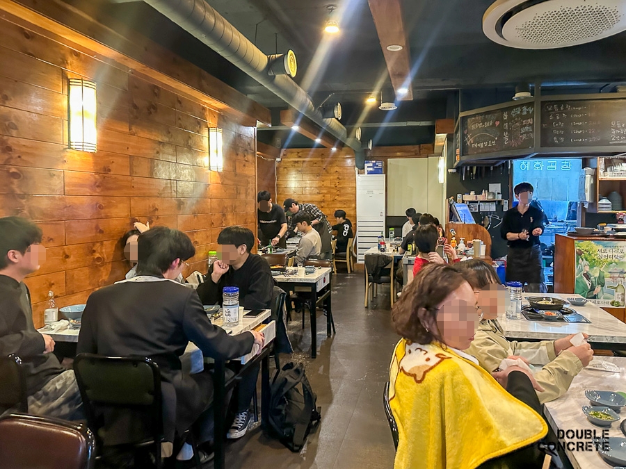혜화곱창 내부 모습과 원목 벽, 테이블 가득 찬 손님들