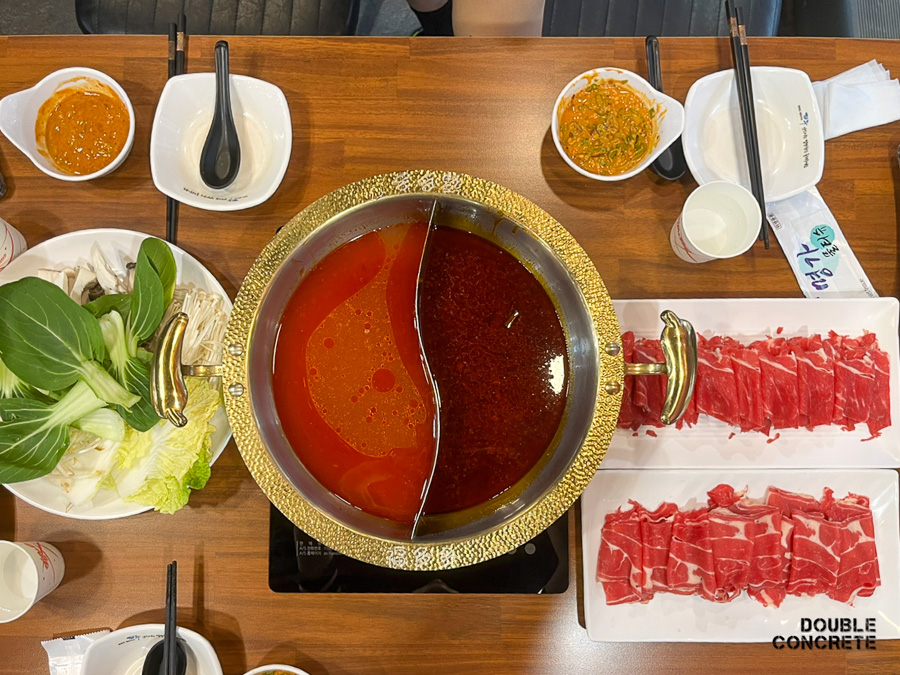 복다다 훠궈 냄비에 담긴 홍탕과 백탕 육수 및 고기, 채소 세팅