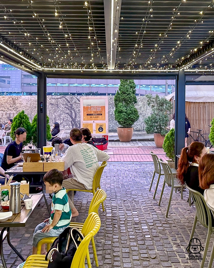 천장 조명이 켜진 벨라시타 사람들 테라스 좌석 풍경