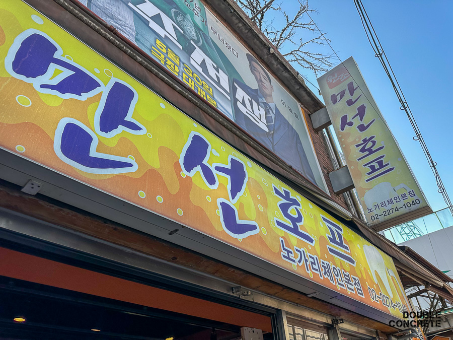 노란색 배경에 큼지막하게 ‘만선호프’라고 쓰인 간판과 영화 ‘소주전쟁’ 현수막