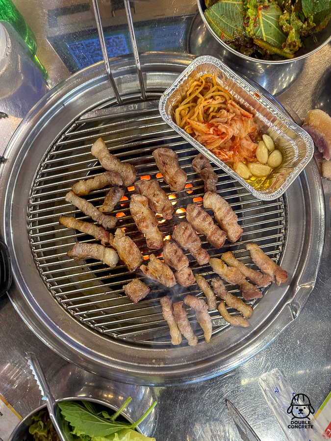연탄불 위에 구워진 돼지껍데기와 반찬