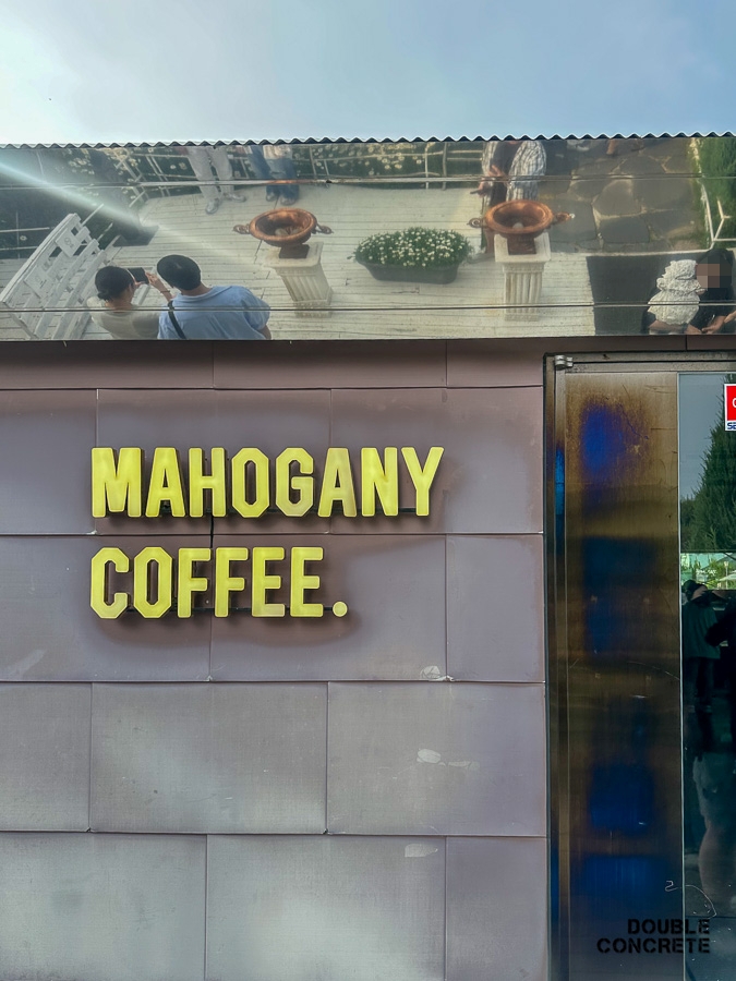 MAHOGANY COFFEE 간판과 금속 반사 외벽