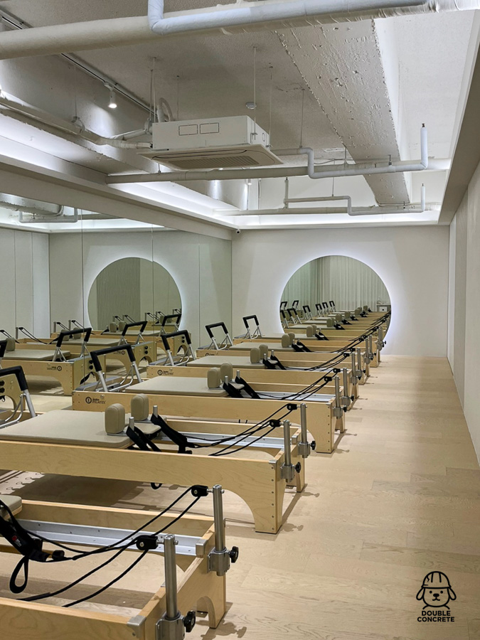 리포머 기구가 일렬로 정돈된 필라테스 수업 공간