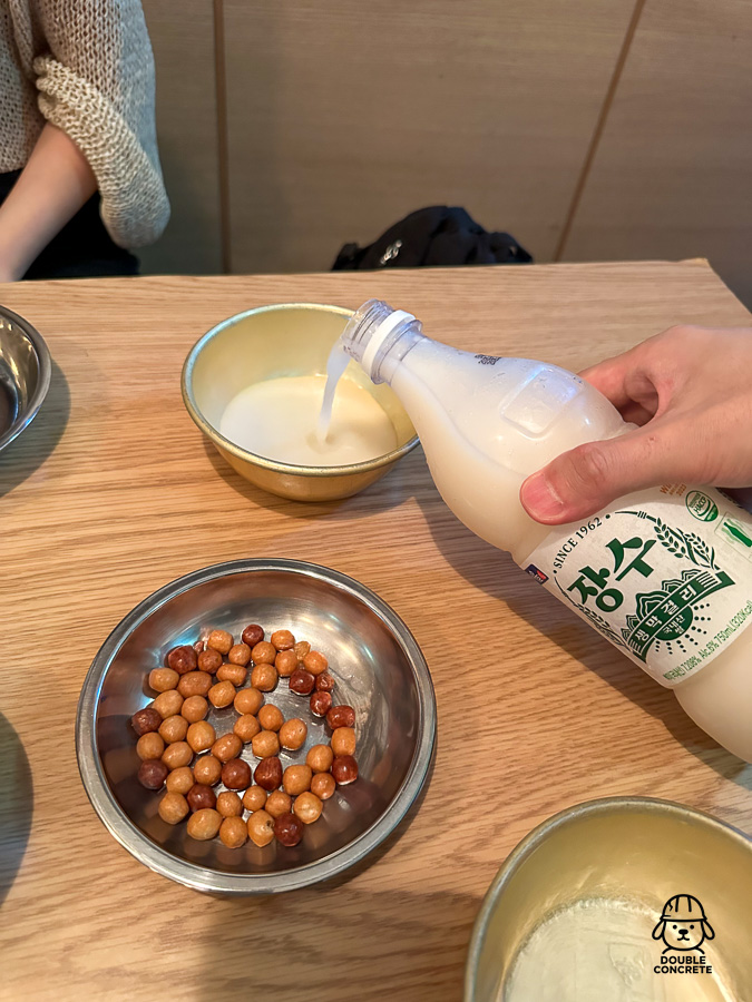 장수막걸리를 잔에 따르고 있는 모습과 기본 안주
