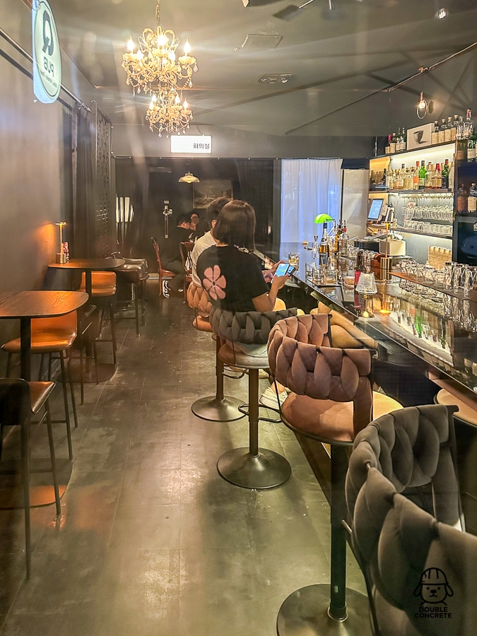 Q PUB 실내 내부 바 테이블과 손님들이 앉아 있는 모습